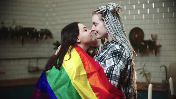 Young Lesbian Women Covered with LGBT Flag  Rub Their Noses and Being Cute