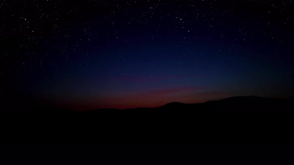 Sunrise with starry sky over the hills