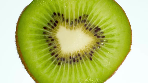 Video of Slice of Kiwi Fruit Squeezing and Exploding on White Background, Perfect Abstract Backdrop