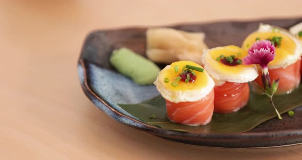 Plate Of Fresh Salmon Rolls Topped With Egg Yolks - close up, slow tracking shot