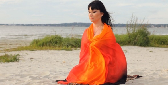 Young Woman Meditating on the Beach