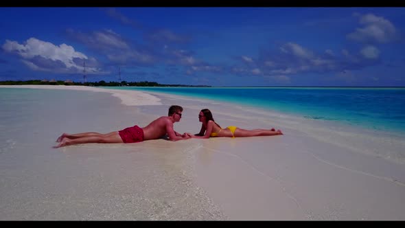 Two lovers suntan on tranquil resort beach journey by aqua blue sea and clean sand background of the