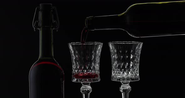 Rose Wine. Red Wine Pour in Two Wine Glasses Over Black Background. Silhouette
