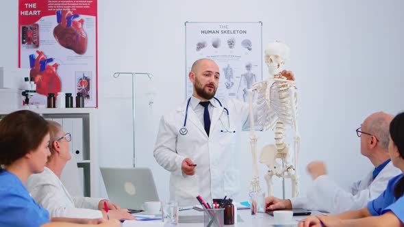 Medical Doctor Man Pointing on Cervical Spine of Human Skeleton