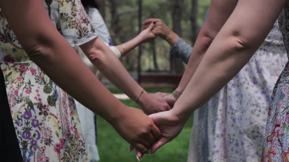 Women in Traditional Dresses Holding Hands at a Folk Festival