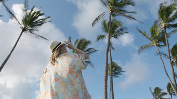 Low Angle Beautiful Girl on Vacation Slow Motion Woman Looking Up on Palm Trees