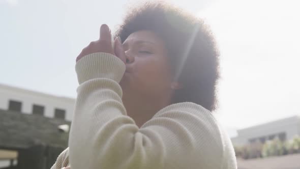 Video of plus size african american woman using inhalator outdoors