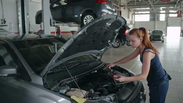 Lady Mechanic Working in Car Service