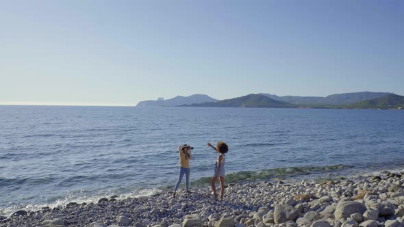 Slow motion shot of female photographer with model at the beach