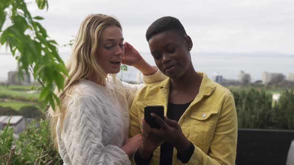 Young women using a smartphone on a rooftop