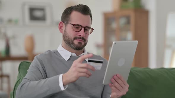 Middle Aged Man Making Online Shopping Payment on Tablet