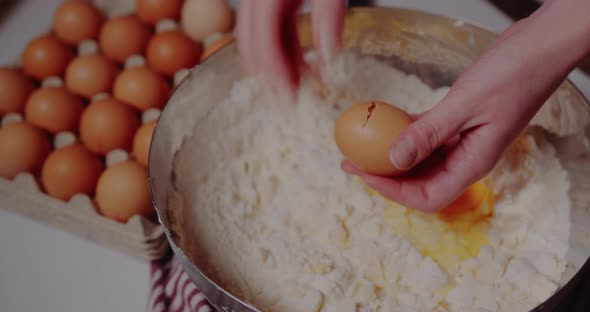 Female Hand Breaks Fresh Chicken Egg Into Bowl