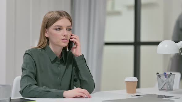 Young Woman Talking on Smartphone at Work 