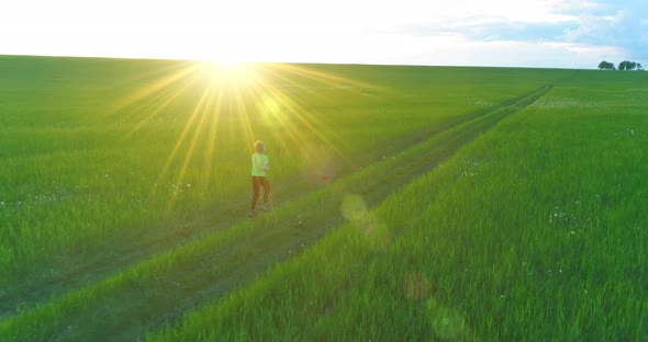 Sporty Child Runs Through a Green Wheat Field