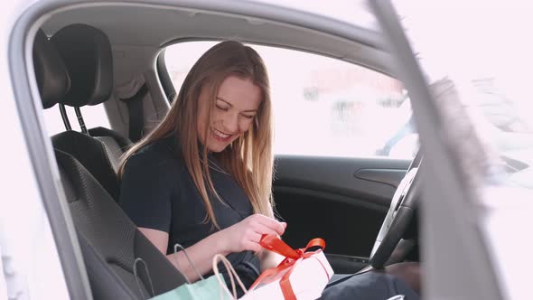 A Beautiful Woman Is Unpacking Her Gift in a Car