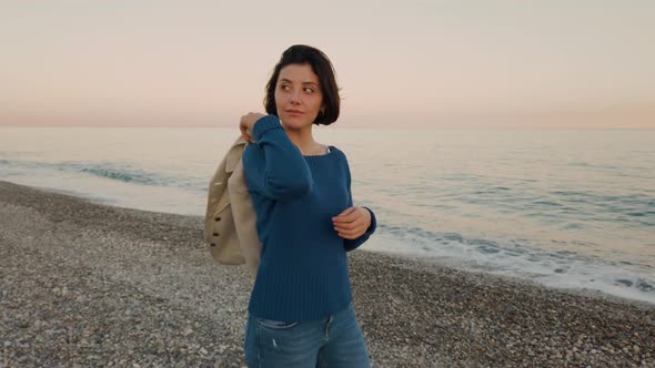 Beautiful Girl Walks at the Beach by the Ocean