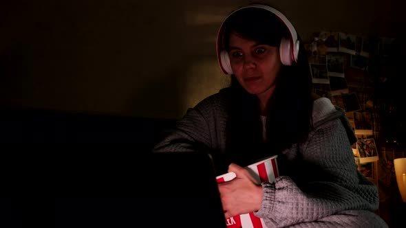 Woman Watching Movie in Headset Eating Popcorn