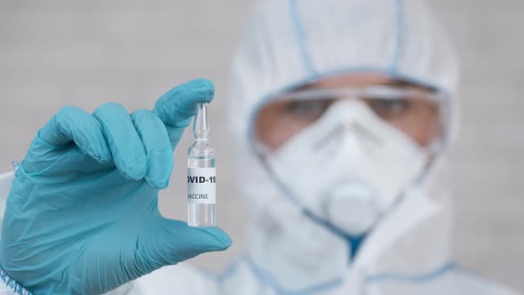 Doctor Showing Coronavirus Vaccine Bottle For Covid19 Vaccination Indoors