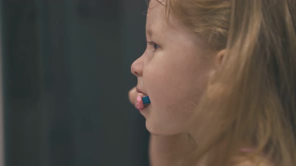 Funny Girl Brushes Teeth Without Paste in Light Bathroom