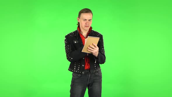 Guy Thinks and Angrily Writes with Pencil in Notebook. Green Screen