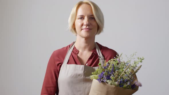 Modest Blonde Florist Posing With Bouquet