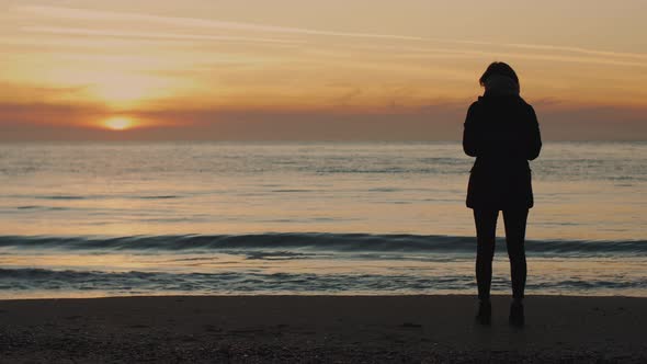 Silhouette of a Young Woman on a Background of the Sea