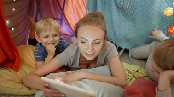 Smiling Woman Playing on Tablet with Little Sons