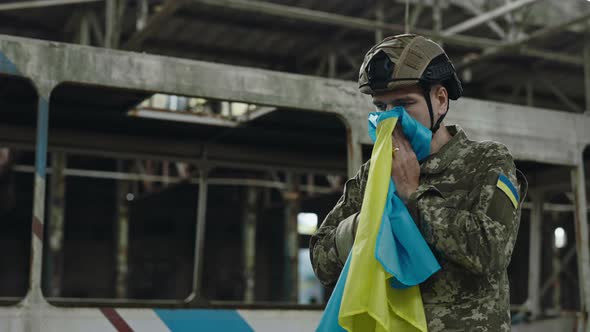 Soldier Holding Ukrainian Flag with Love on Factory