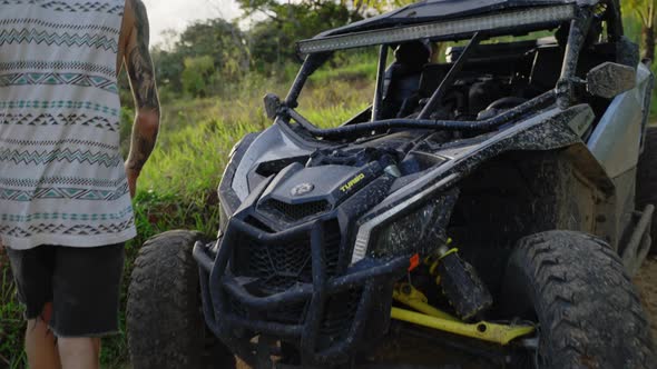 Dolly Shot Of Male Walking Past Parked Dirt Buggy To View Sunset At Punta Cana. Slow Motion