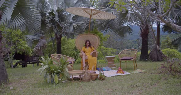 Wide Shot of Woman Sitting on Wood Chair and Umbrella During Picnic