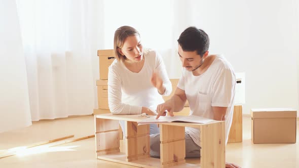 Couple Installing Furniture in New House with Instruction