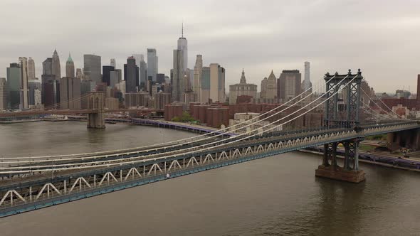 An aerial view over the East River on a cloudy day. The drone camera trucks right along the Northsid