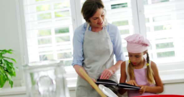 Mother and daughter looking recipe book