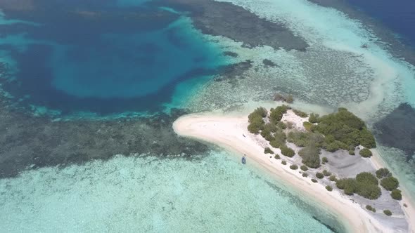 Aerial drone shot of idyllic tropical island seascape with turquoise and clean water and boats in th