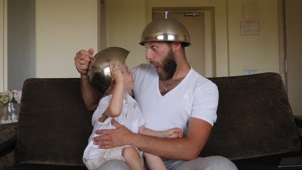 Father Is Playing with His Little Son with the Lids From the Dishes in the Hotel