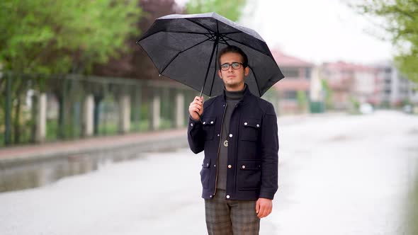 Young Man Walking Through Rainy Weather