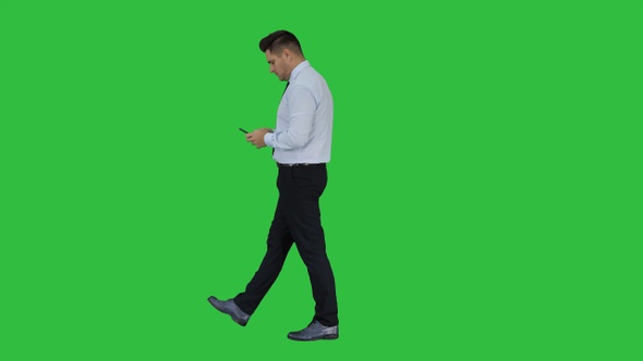 Mature man walking and using mobile phone on a Green Screen