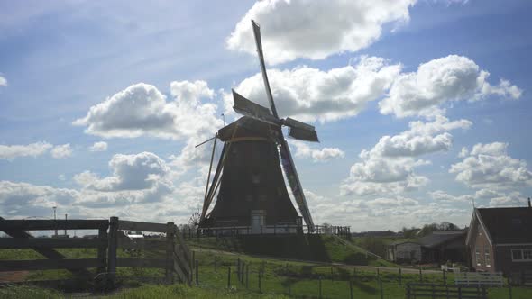 View Of Old And Unique Windmill In Netherlands On A Sunny Day In The Farm - wide shot