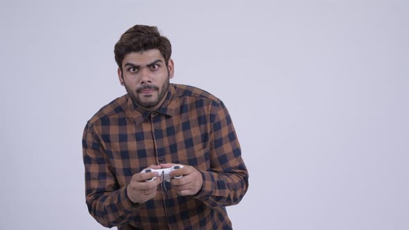 Happy Young Bearded Indian Hipster Man Playing Games and Winning