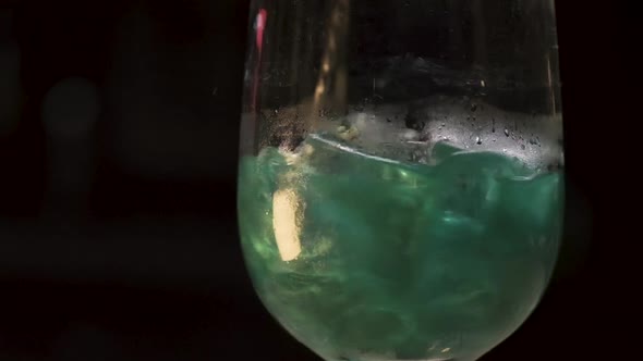 Stirring alcohol with ice cubes in the glass