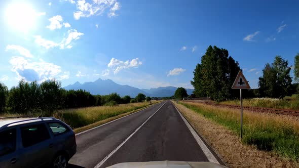 POV shot of driving a car on the road along the forest and mountains. Traveling in the summer by car