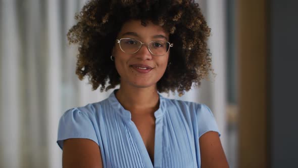 Portrait of mixed race woman with curly hair looking at camera and smiling