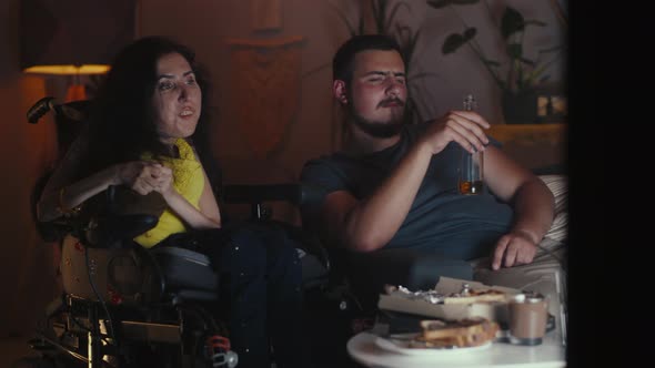 Woman in Wheelchair with Husband Near TV