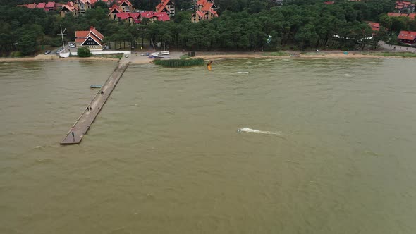 AERIAL: Active People Practicing Kite Surfing and Windsurfing on a Cloudy Day