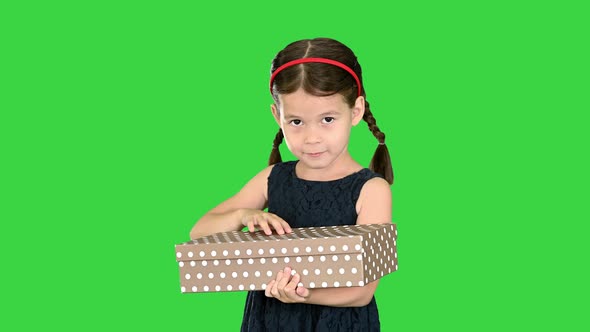 Happy Girl in Black Dress Shaking and Opening Gift Box Smiling at Camera on a Green Screen, Chroma