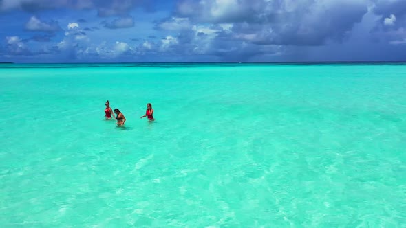 Girls tan on paradise island beach holiday by aqua blue sea with white sandy background of the Maldi