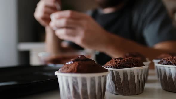 A Pastry Chef in the Kitchen Is Putting Chocolate in a Chocolate Muffin