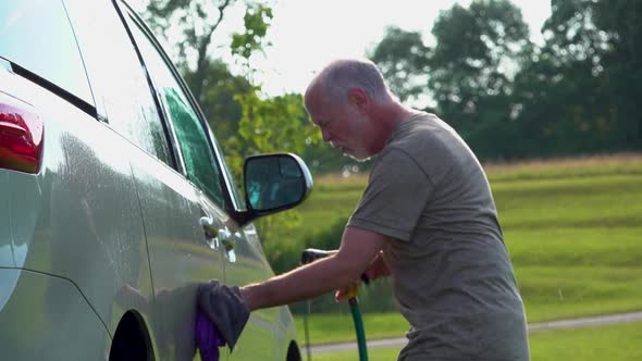 Dancing man washing car in slow motion.