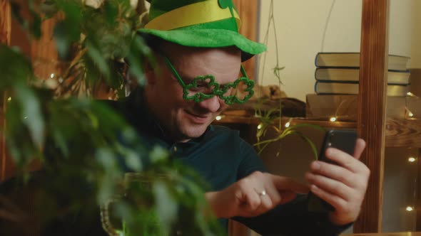 Man Celebrating Saint Patricks Day at Home Scrolling Social Media