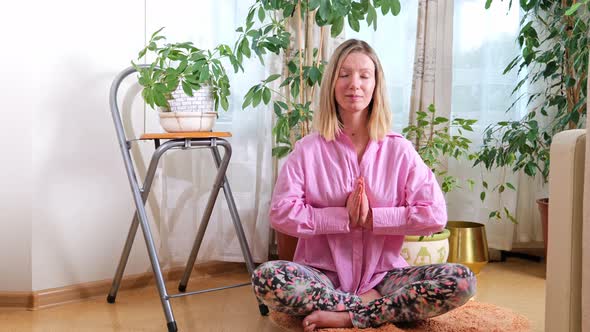 Young sportive woman practicing yoga and meditation at home